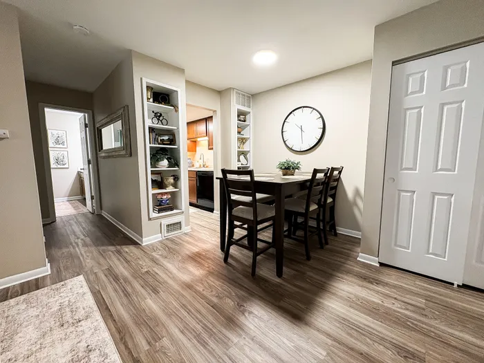 Inviting modern dining area with elegant wooden table, surrounding chairs, and built-in shelving, perfect for family gatherings.