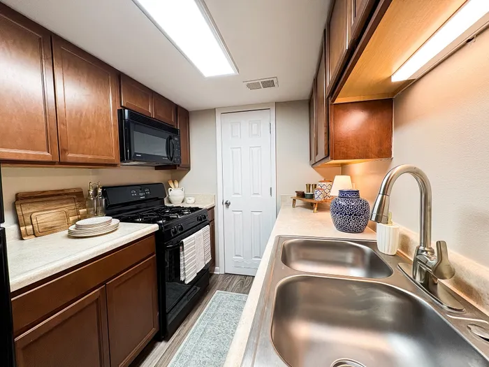 Charming modern kitchen with sleek wooden cabinets, elegant countertops, and contemporary lighting.