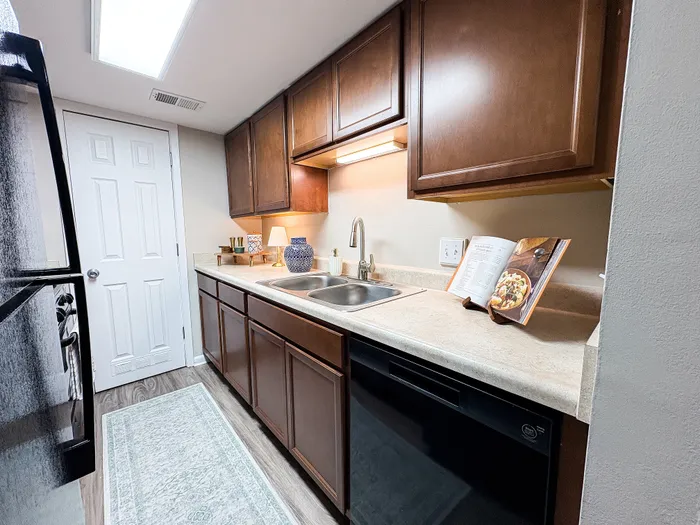 Charming kitchen space with rich wood cabinetry, modern appliances, and elegant countertop accents, perfect for culinary enthusiasts.