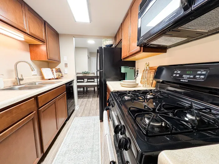 Charming kitchen with modern appliances, sleek countertops, and warm wood cabinetry, leading to a cozy dining area.
