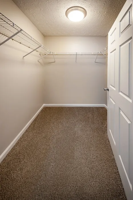 Spacious walk-in closet with modern lighting and ample shelving, perfect for organized storage at Cypress Square Apartments in Lafayette, IN.