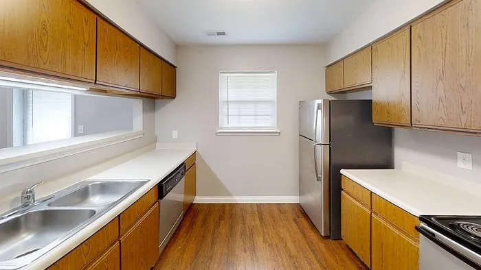 Inviting kitchen with wood cabinetry, modern appliances, and sleek countertops, perfect for culinary creativity.