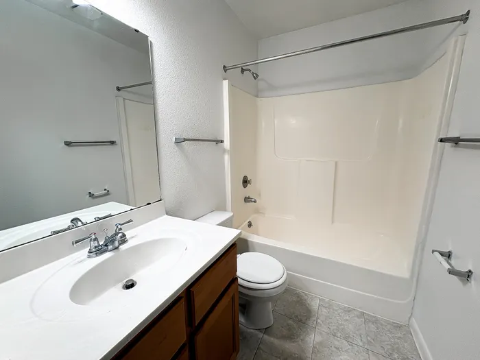 Modern bathroom design featuring a sleek vanity, large mirror, and a pristine bathtub with elegant fixtures.