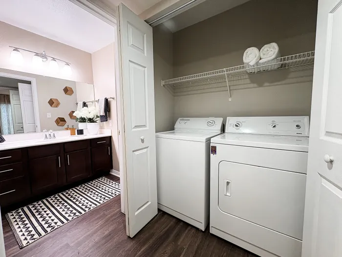 River Crossing modern bathroom with sleek cabinetry, elegant lighting, and a convenient in-unit washer and dryer.