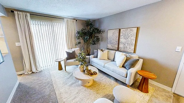 Bright, modern living room with a cozy white sofa, elegant decor, and natural light streaming through large windows.