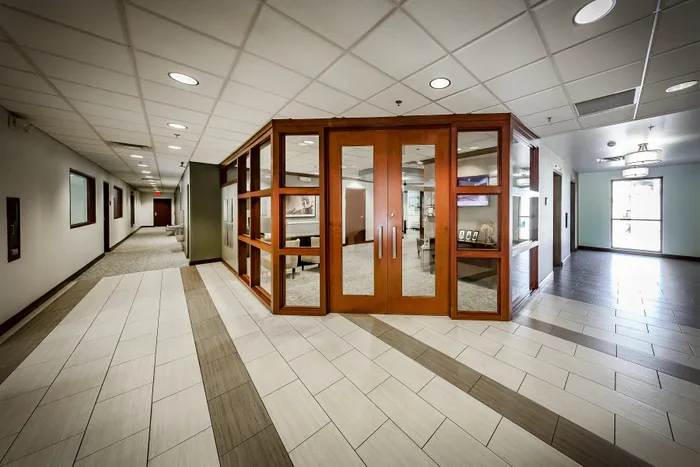 Elegant office lobby featuring modern tiled floors, refined wooden accents, and a spacious hallway.