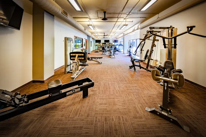 Modern fitness center with state-of-the-art equipment, bright lighting, and ample space for a comfortable workout experience.