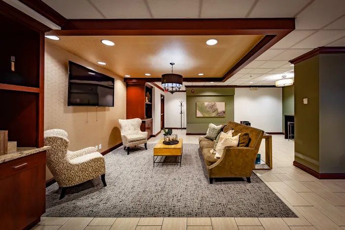 Elegant lounge area featuring cozy armchairs, a plush sofa, and modern decor with ambient lighting, perfect for relaxation and socializing.