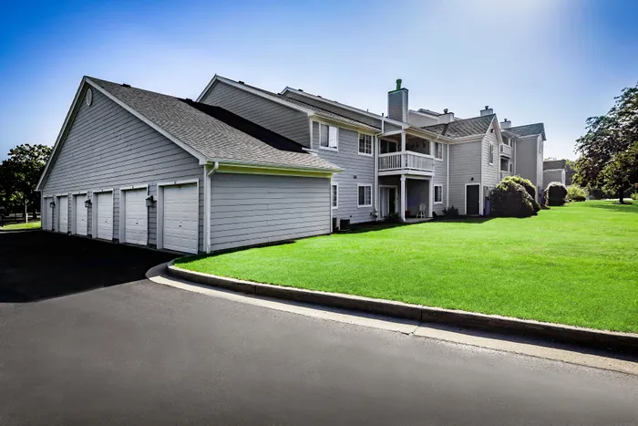 Charming apartment community showcasing modern architecture, pristine white paint, and inviting green lawns, perfect for comfortable living.