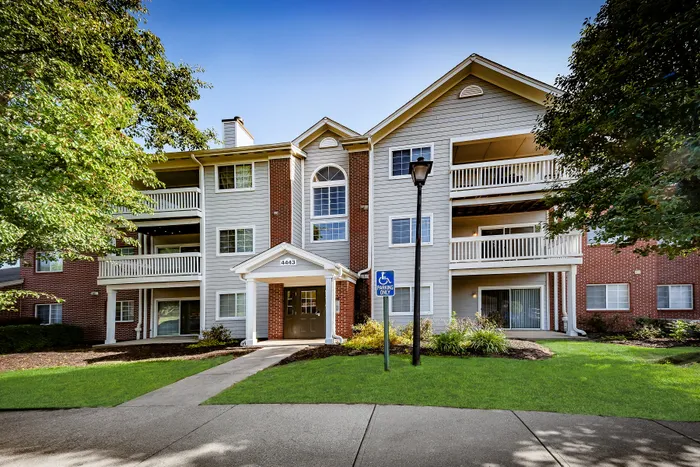 Charming apartment building with spacious balconies, elegant entrance, and lush greenery, perfect for a cozy and modern lifestyle.