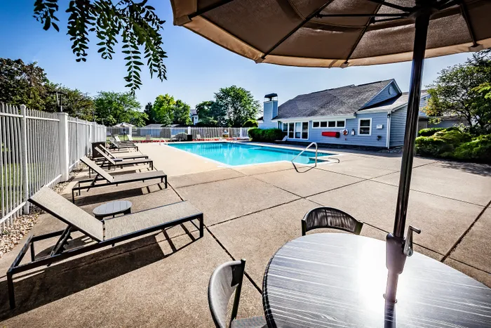 Inviting outdoor pool area with sun loungers and shaded seating, perfect for relaxation and enjoyment.