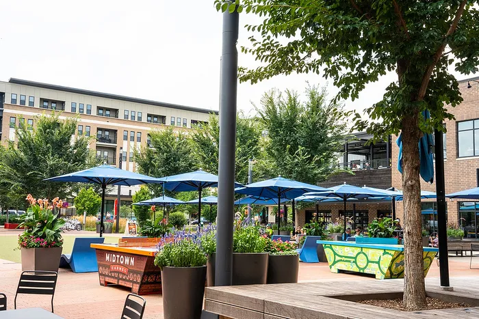 Midtown Carmel Indiana outdoor plaza with blue umbrellas and ping-pong table