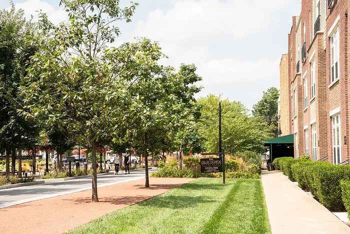 Old Town Carmel Indiana apartments, tree-lined sidewalk and landscaping overlooking the Monon Trail.