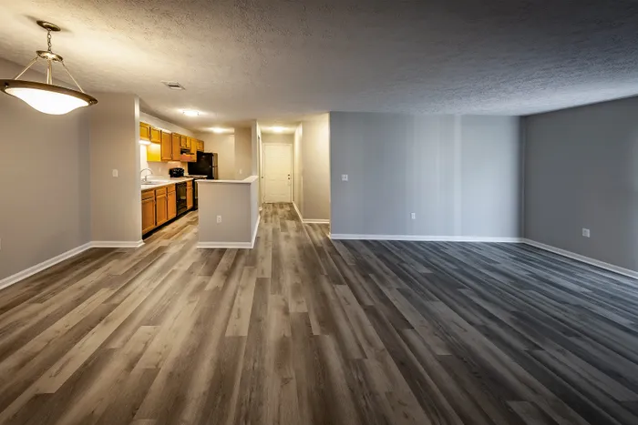 Spacious open-plan living area featuring modern hardwood flooring and a stylish kitchen with warm wood cabinetry.