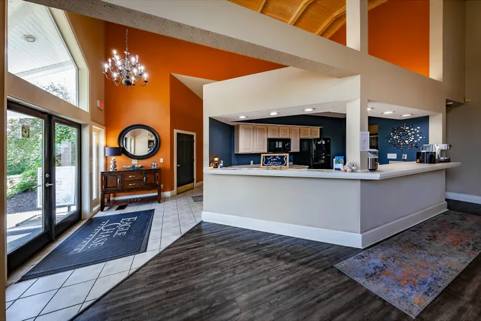 Inviting clubhouse lobby with high ceilings, modern decor, and a welcoming reception desk, bathed in natural light from large windows.
