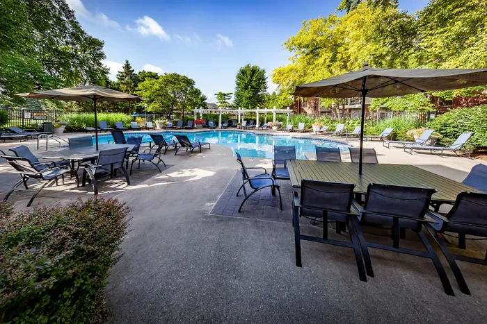 Luxurious outdoor pool area with stylish seating and lush greenery, perfect for relaxation and entertainment.