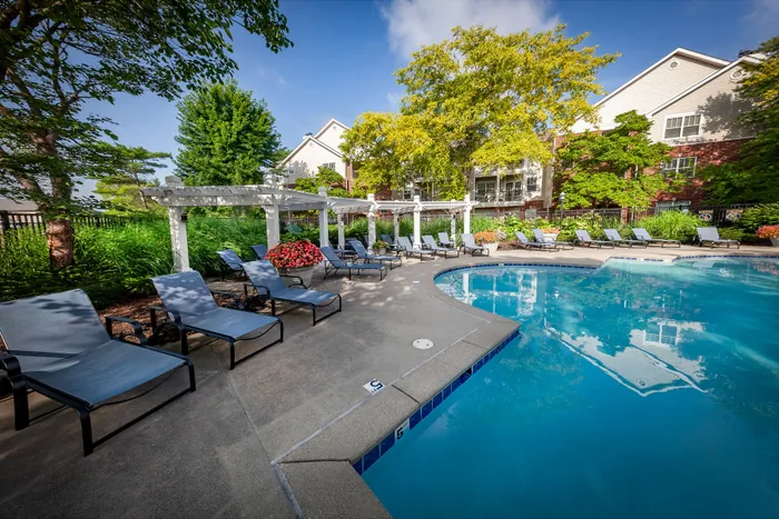 Inviting outdoor pool area with lush greenery, comfortable lounge chairs, and a serene atmosphere perfect for relaxation.
