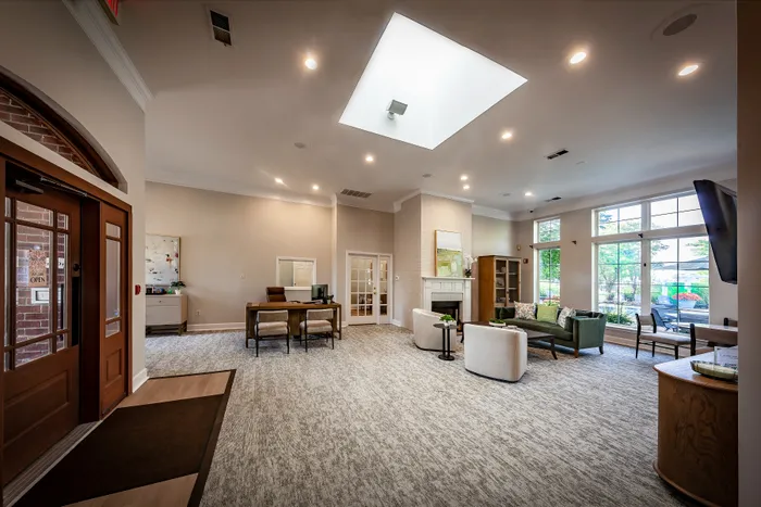 Inviting and spacious lounge area with elegant seating, large windows, and a skylight creating a bright and welcoming environment.