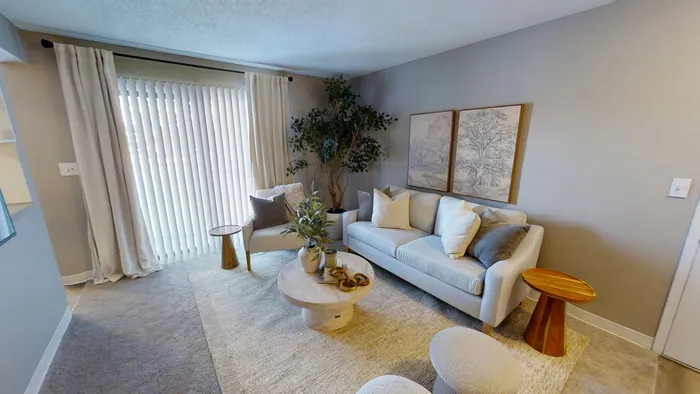 Pebble Point inviting living room with elegant decor, soft neutral tones, plush seating, and abundant natural light through large sliding doors.