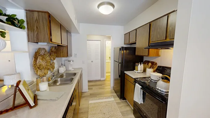 Pebble Point charming kitchen with elegant wooden cabinets, sleek countertops, and modern appliances, featuring stylish decorative elements and a cozy atmosphere.