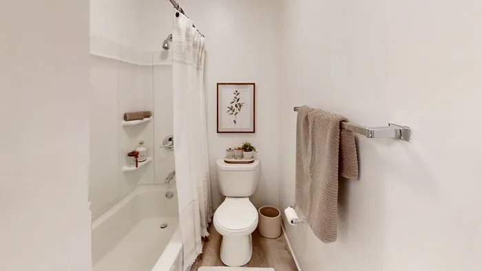 Pebble Point chic bathroom featuring a cozy bathtub, elegant shower curtain, and tasteful wall art, creating a serene oasis.