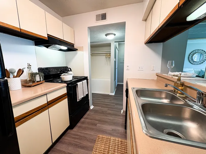 Modern kitchen with sleek appliances, ample counter space, and elegant cabinetry leading to a cozy living area.