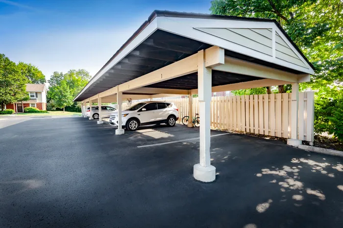 Main Street on the Monon Apartments - Bright, covered parking area with spacious spots and lush greenery, perfect for convenient vehicle storage.