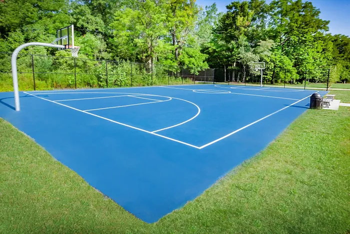 Main Street on the Monon Apartments - Vibrant outdoor basketball court surrounded by lush greenery, perfect for community sports and recreation.