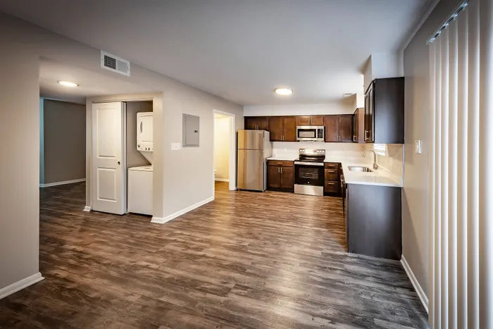 Main Street on the Monon Apartments - Spacious modern kitchen with sleek dark wood cabinets, stainless steel appliances, and stylish wood flooring in an open apartment layout.