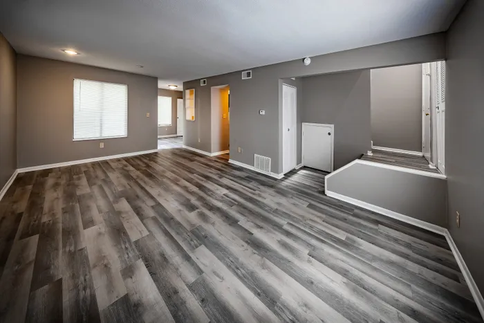 Pebble Point Apartments - Spacious modern living area with sleek wood flooring and abundant natural light, perfect for comfortable living.