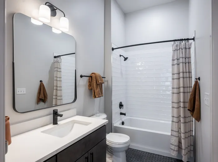 The Elex Apartments - Modern bathroom with a sleek design, featuring a spacious vanity, elegant lighting, and a stylish bathtub.