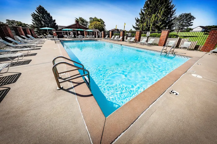 Inviting outdoor pool surrounded by elegant loungers and lush greenery, perfect for relaxation and leisure.