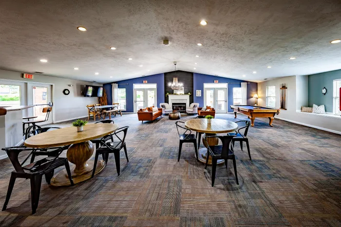 Inviting communal space featuring modern tables, cozy seating, and a stylish fireplace, perfect for social gatherings.