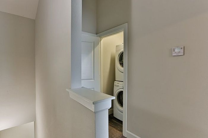 Modern apartment interior featuring convenient in-unit laundry with stacked washer and dryer.