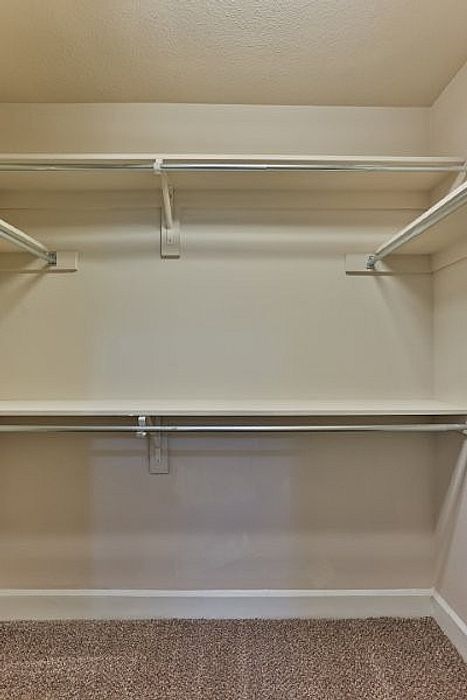 Spacious walk-in closet with ample shelving and neutral tones, ideal for organizing a stylish wardrobe.