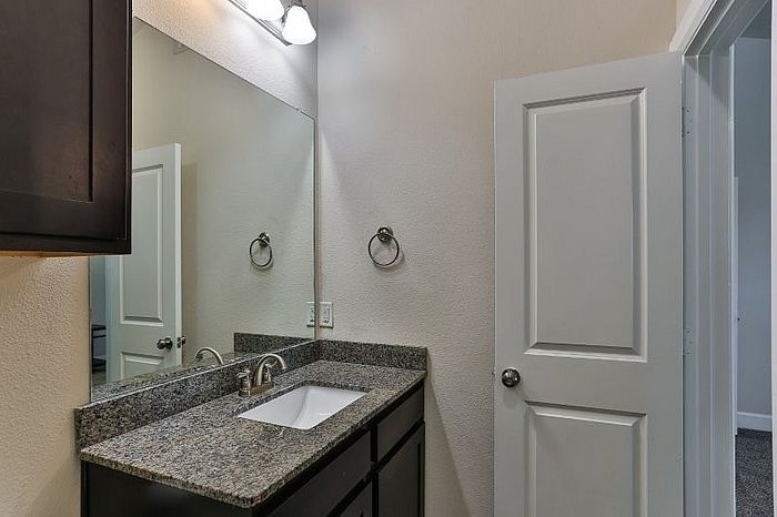 Modern bathroom with sleek granite countertop, elegant sink fixtures, and soft lighting creating a soothing ambiance.