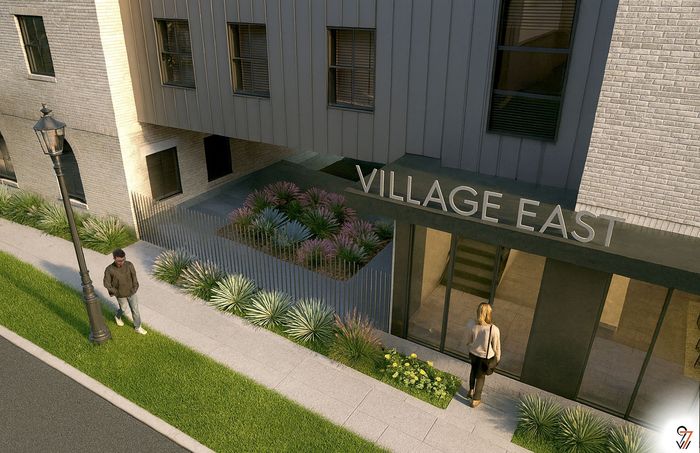 Chic entrance of Village East featuring modern architecture, vibrant landscaping, and welcoming ambiance.