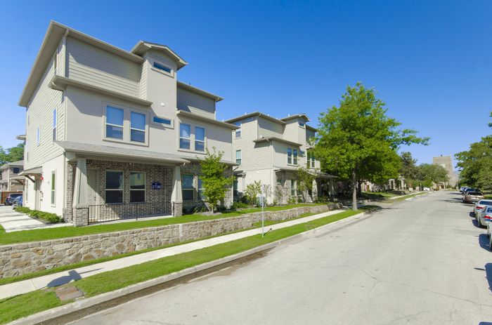 Charming, modern townhouses with landscaped gardens on a quiet, tree-lined street.