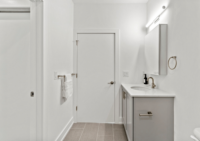 Minimalist bathroom with white vanity and contemporary lighting.