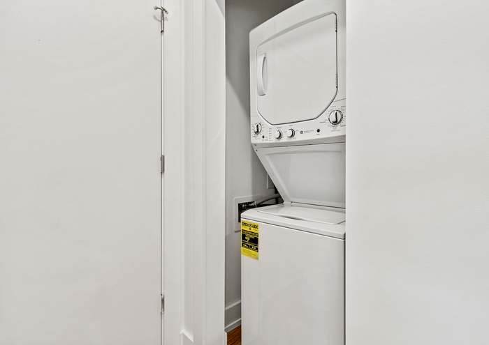 Efficient laundry area featuring a stackable washer and dryer within a sleek white closet.