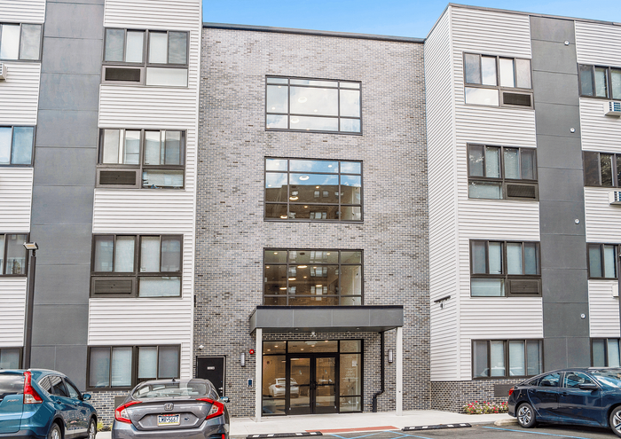 Modern apartment building facade with large windows and sleek design.
