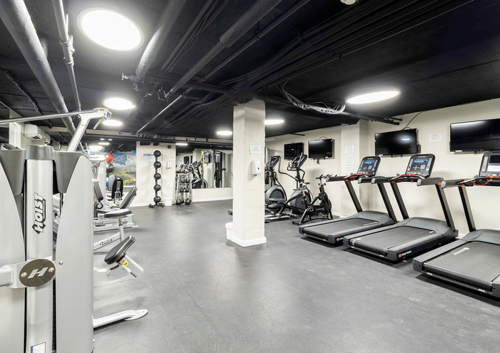 Modern fitness center with treadmills, elliptical machines, and strength training equipment.