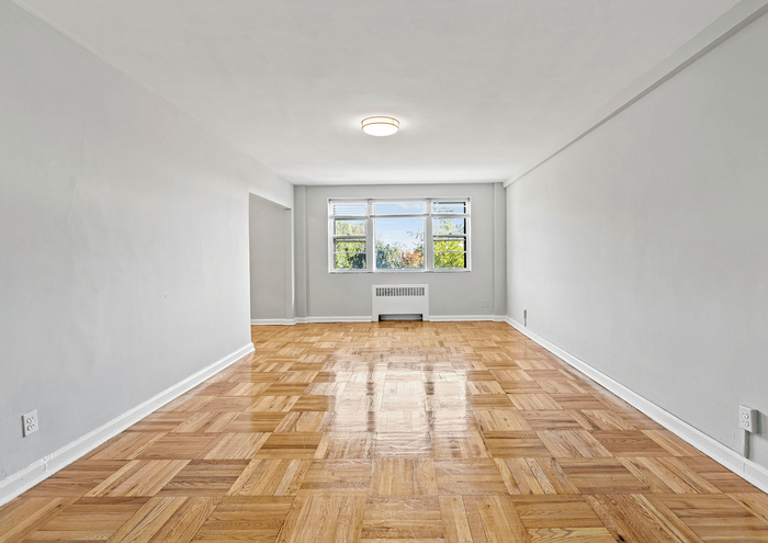 Inviting open living space with polished hardwood floors and natural light streaming through large windows.