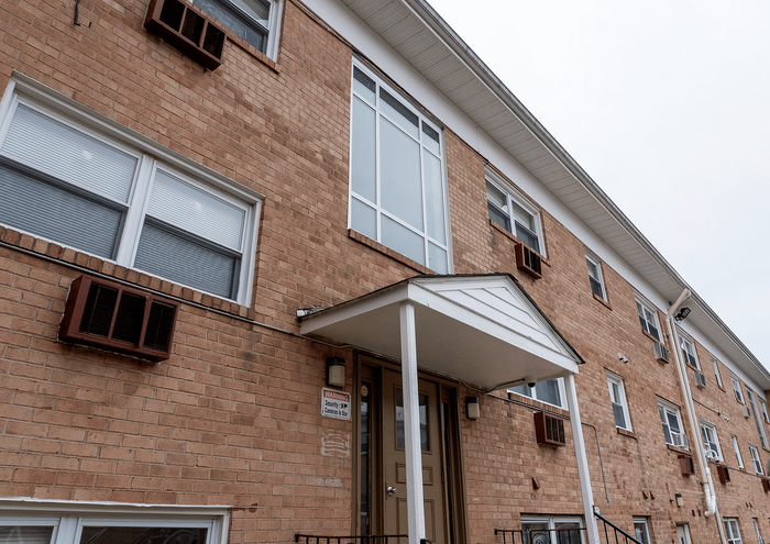 Inviting brick apartment building with large windows and cozy entrances.