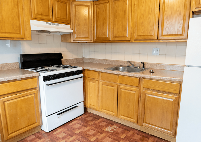 Bright kitchen with wooden cabinets, gas stove, and efficient layout.