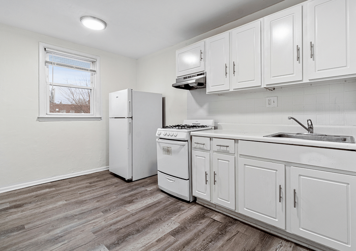 Bright, modern kitchen with white cabinetry and stainless steel appliances.