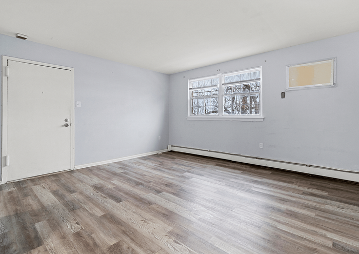 Spacious living room with laminate wood flooring and a large window.