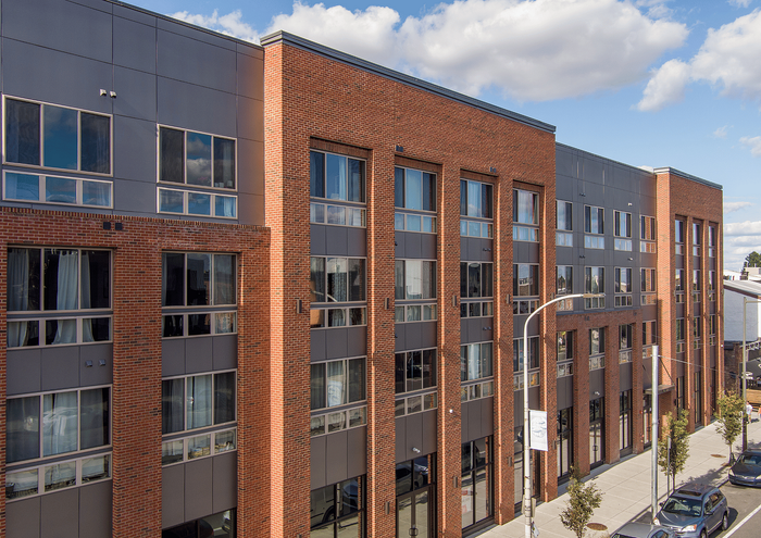 Contemporary brick apartment building with large windows and modern design.