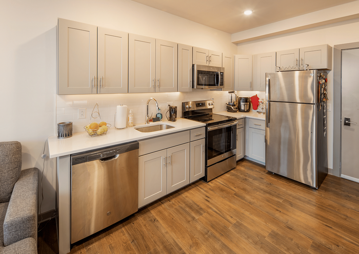 Chic kitchen with modern stainless steel appliances and sleek light gray cabinetry.