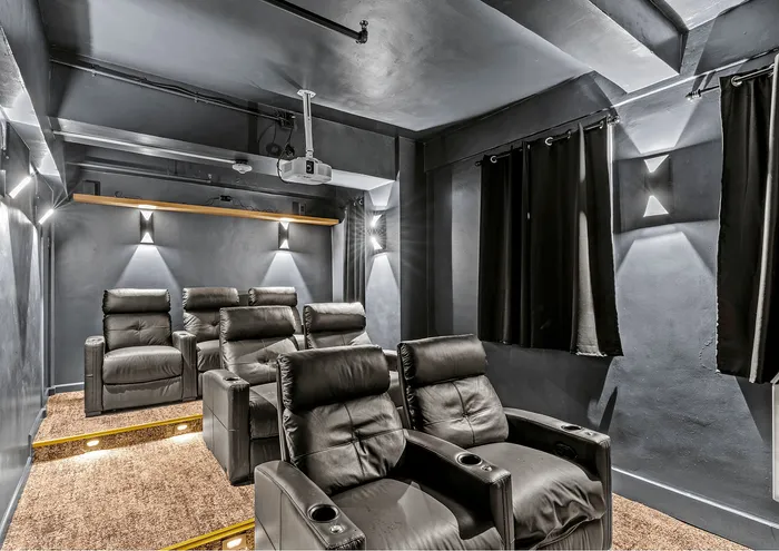 Elegant home theater with plush recliners and dim ambient lighting.